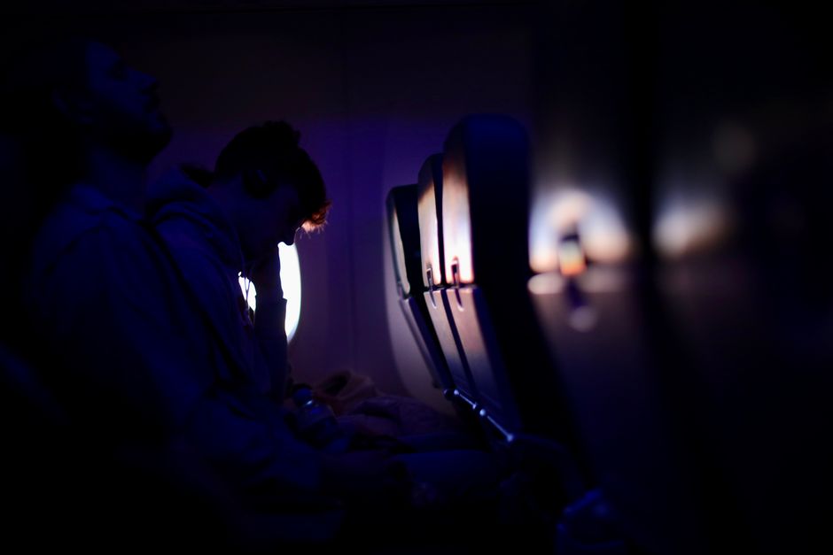 Passengers resting in a dimly lit airplane cabin