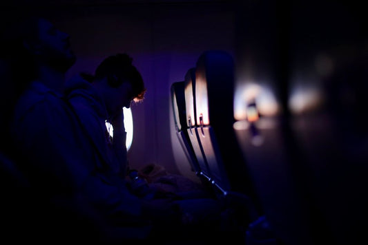 Passengers resting in a dimly lit airplane cabin