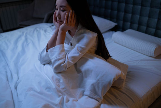 Woman awake and thoughtful in bed at night
