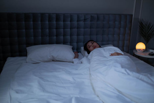 Woman lying awake in a dim bedroom at night
