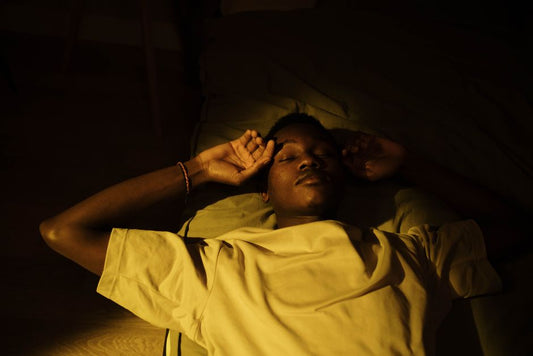 A person sleeping in a warm, dimly lit bedroom