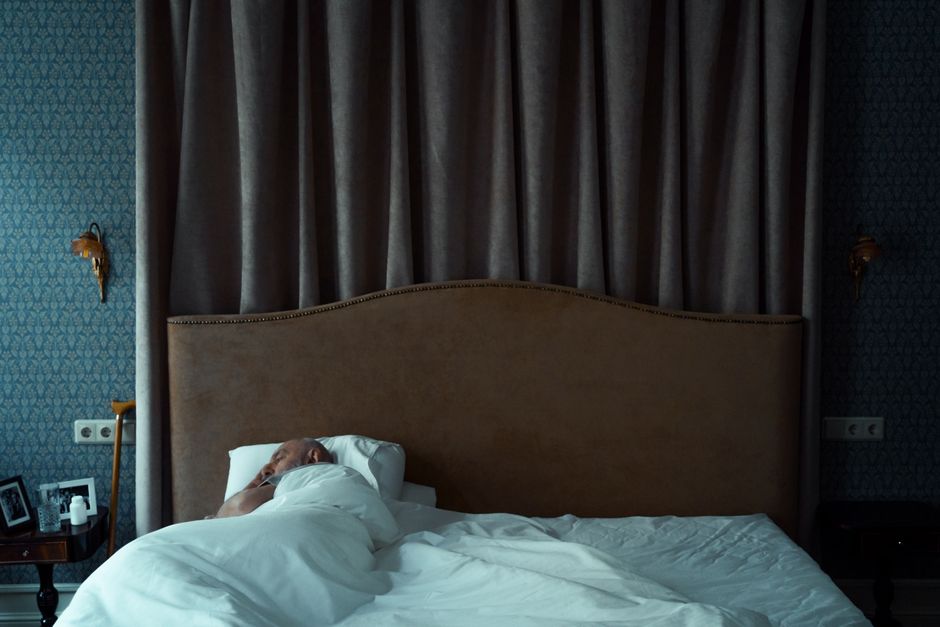 A person sleeping in a dim, peaceful bedroom